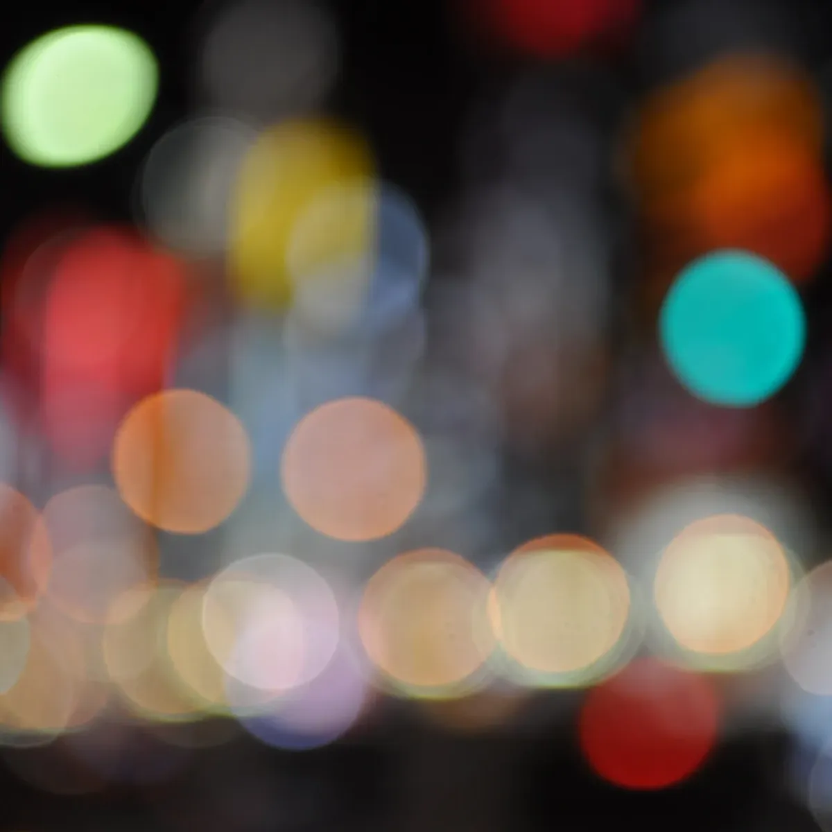 Blurred colourful city lights forming soft bokeh circles at night