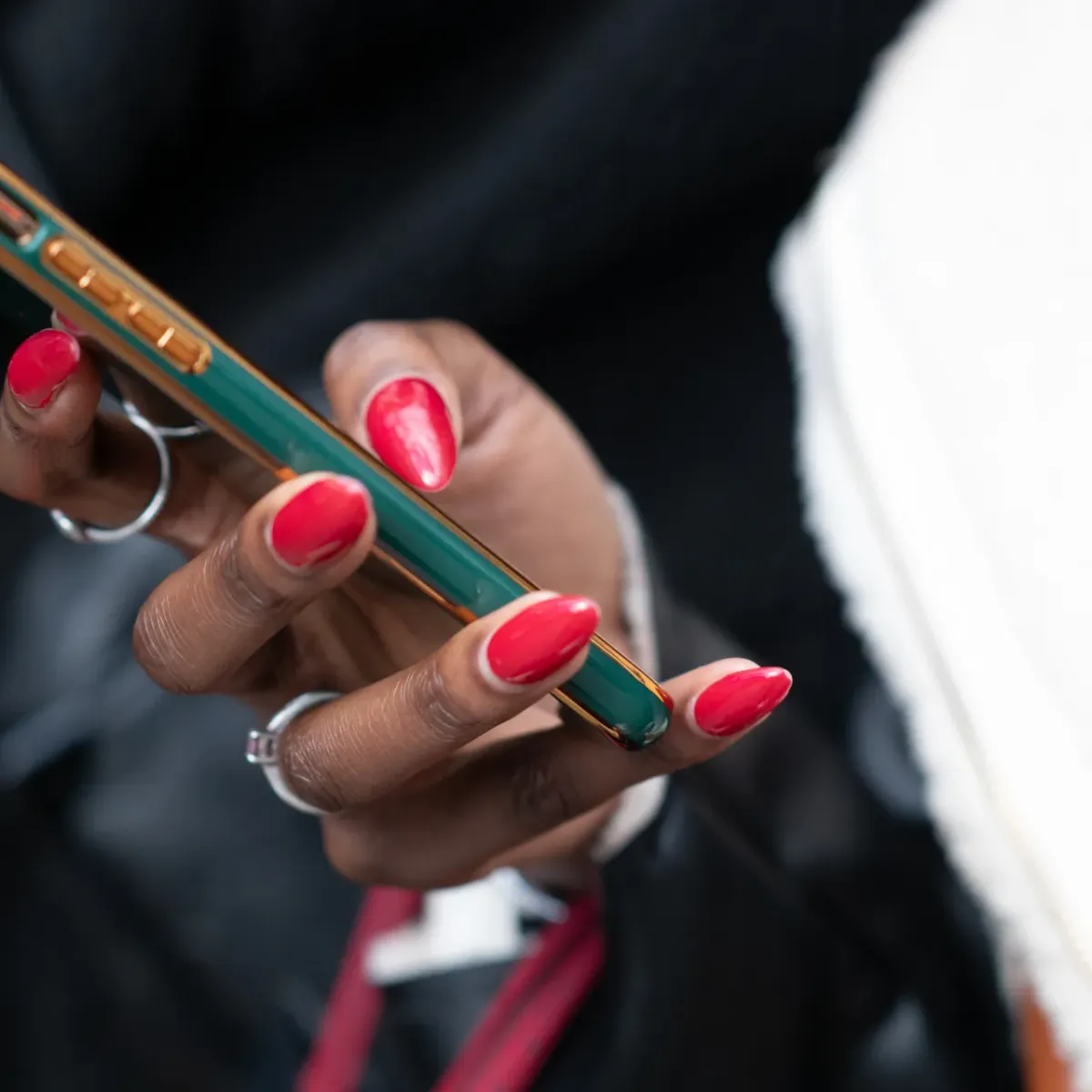 Hand with red nails holding a green smartphone